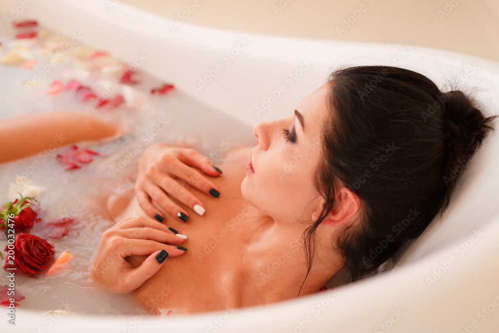 Fototapeta premium Brunette woman relaxing in the milk bath
