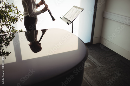 Woman playing a clarinet in music school photo