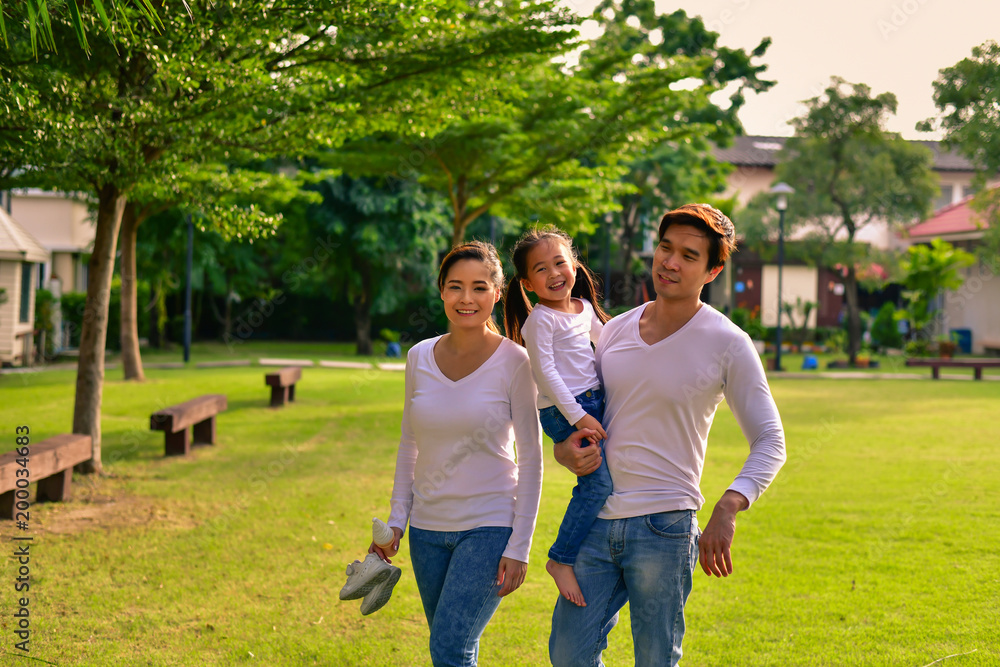 Fototapeta premium Parents and daughters go for a walk in the park.