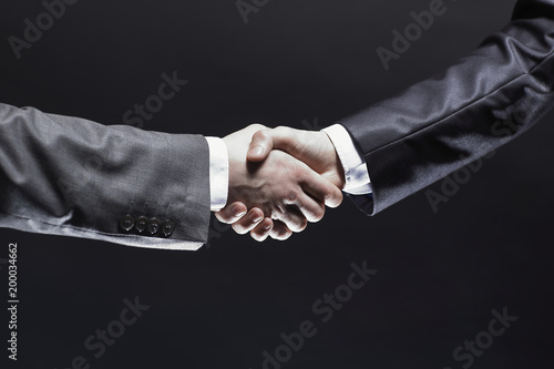 close up. handshake business partners.isolated on black background