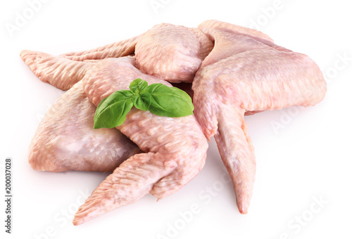 Raw chicken wings and basil isolated on white background.