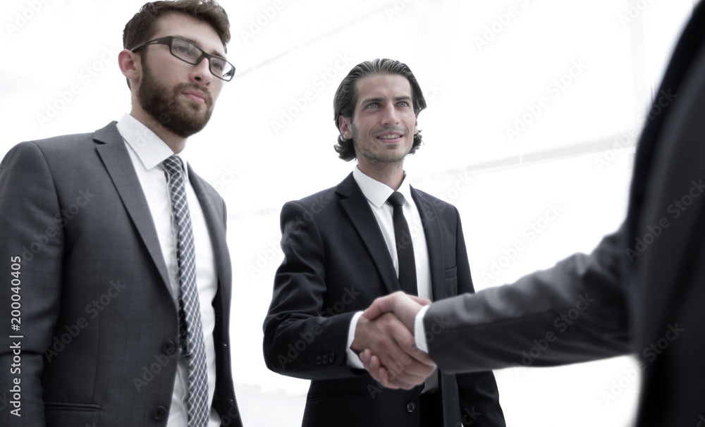 business group welcomes partner with a handshake business group welcomes partner with a handshake
