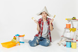 Fun woman in newspaper hat sitting on floor with brush, instruments for renovation apartment room isolated on white background. Wallpaper, accessories for gluing, painting tools. Repair home concept.