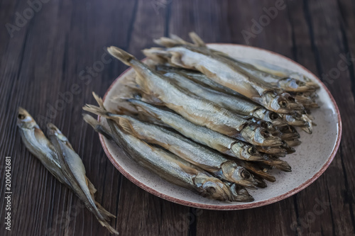 Capelin smoked on brown wooden table.