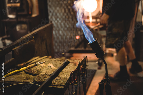 Close-up of marvers table with blow torch and glassblowing tools photo