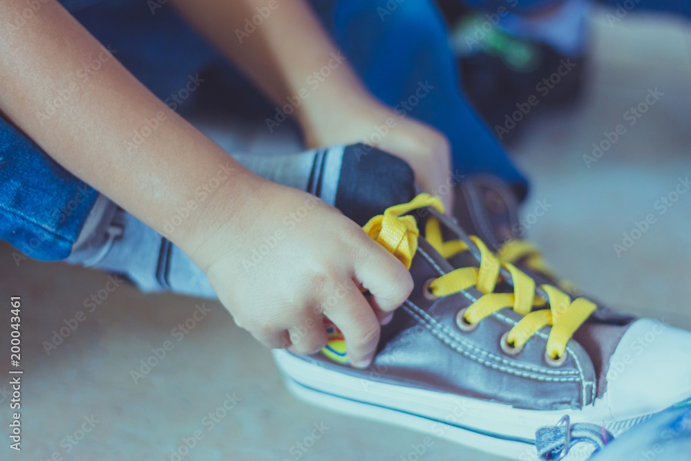 Kid is tying shoes laces before stage show in school