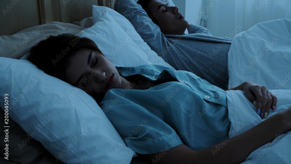 The young married sleeping on bed at night The young married sleeping on bed at night