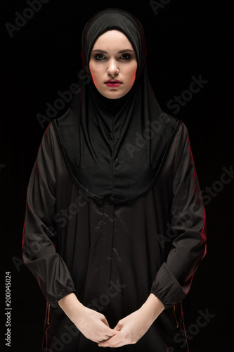 Foto Beautiful young woman wearing black hijab as conservative fashion concept on bla