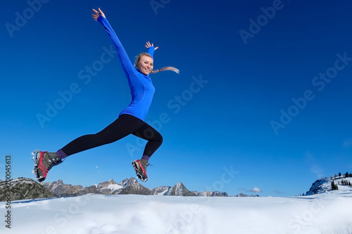 Jumping with joy.  Young pretty girl jumping in mountains.  Crater Lake. Oregon. United States.