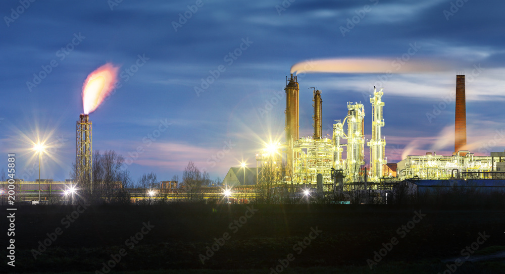 Oil Refinery at night with smoke stack