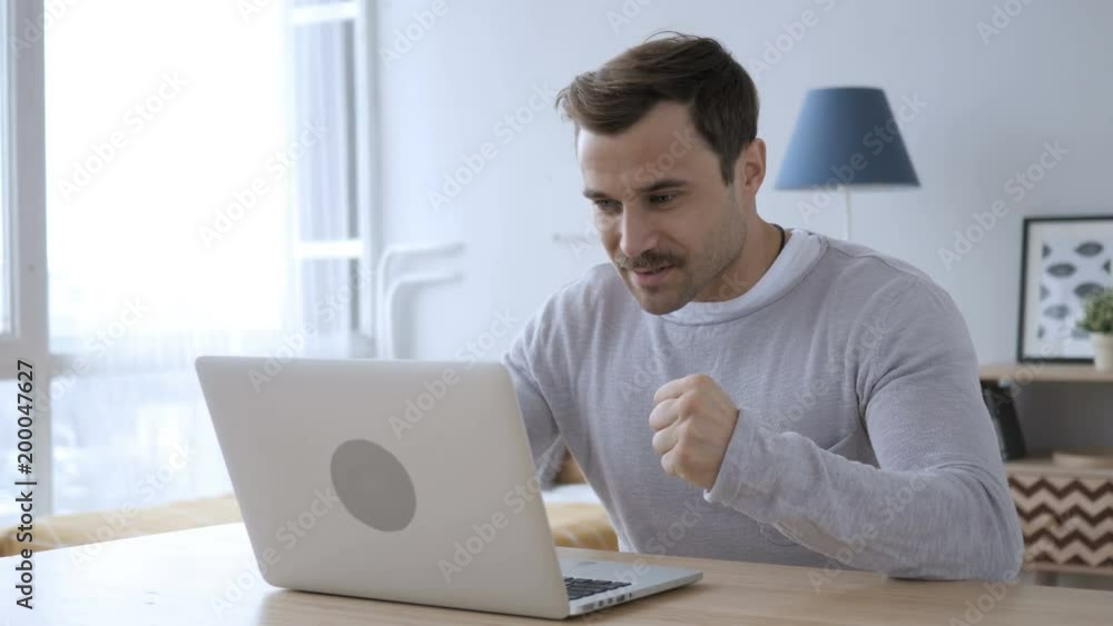 Excited Adult Man Celebrating Success, Working on Laptop Excited Adult Man Celebrating Success, Working on Laptop
