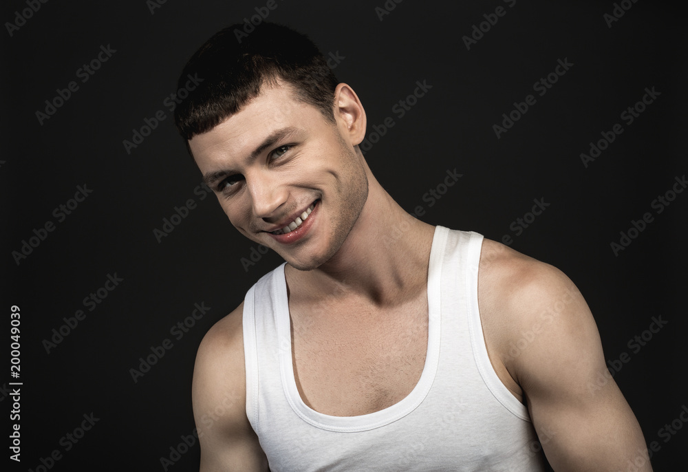 Portrait of glad male with attractive smile isolated on black background. Cheerfulness concept Portrait of glad male with attractive smile isolated on black background. Cheerfulness concept