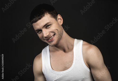 Portrait of glad male with attractive smile isolated on black background. Cheerfulness concept