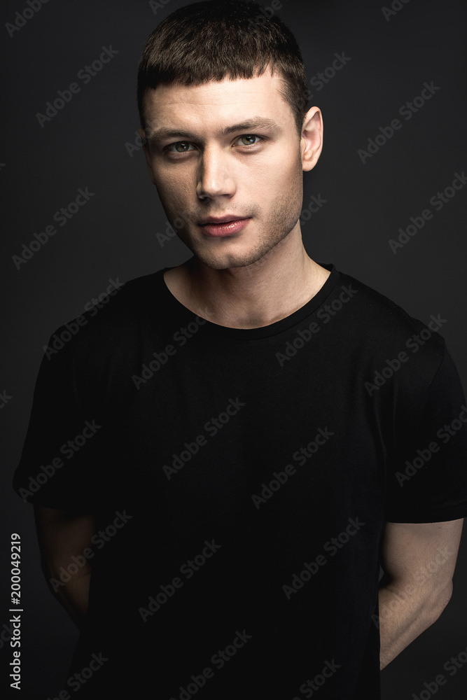 Fototapeta premium Portrait of focused young man isolated on black background. Concentration concept