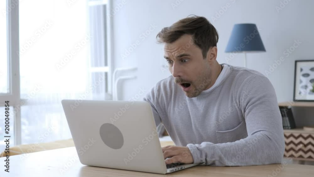 Wondering Adult Man Working on Laptop in Shock Wondering Adult Man Working on Laptop in Shock