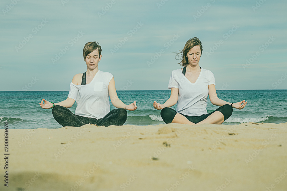 Girls practicing yoga on the beach Girls practicing yoga on the beach