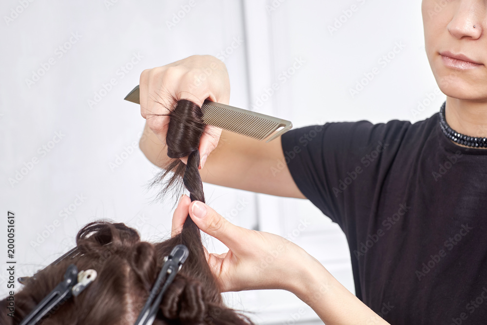 Naklejka premium hair stylist making new haircut to brunette woman in salon