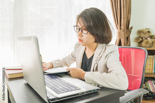 Woman teenage working on laptop in home office
