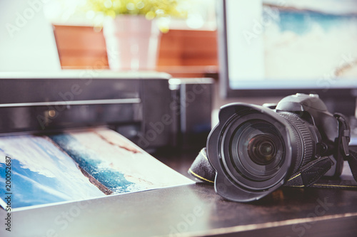 Desk with a DSLR camera and wirelles printer photo