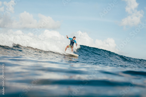 Εκτύπωση καμβά side view of young sportsman in wetsuit having fun on surfboard on sunny day