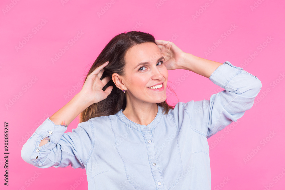 Smiling Woman in shirt posing in studio on pink background Smiling Woman in shirt posing in studio on pink background