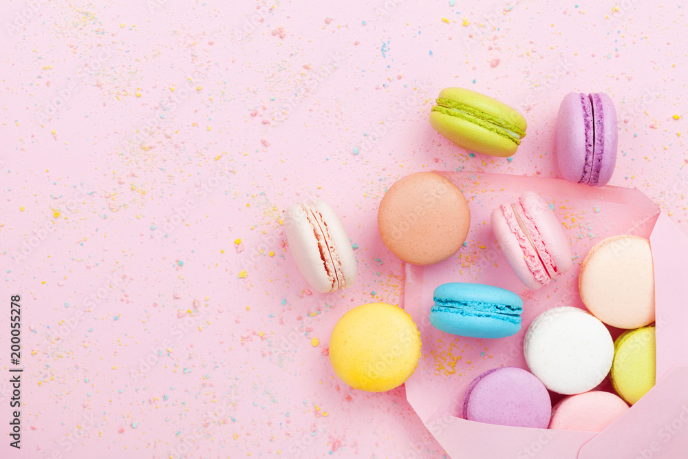 Creative composition with envelope and cake macaron or macaroon on pink pastel background top view. Flat lay. Creative composition with envelope and cake macaron or macaroon on pink pastel background top view. Flat lay.