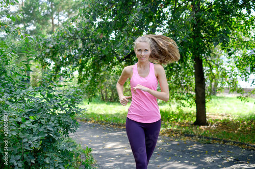 Attractive young woman jogging on park trail. healthy lifestyle concept