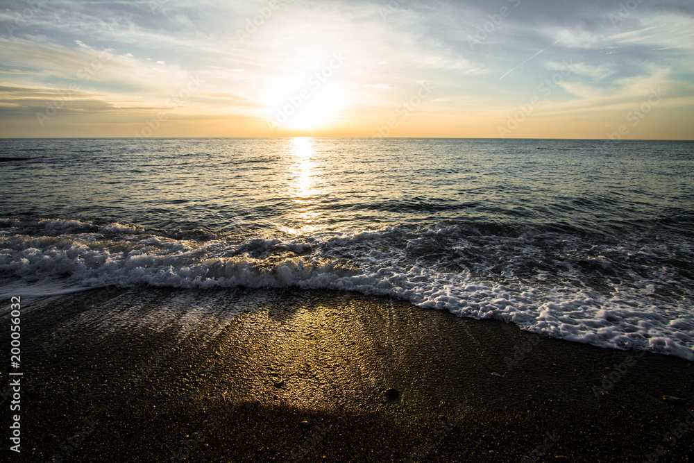 Coastal waves at sunset. Colorful sunset on a sea beach. Coastal waves at sunset. Colorful sunset on a sea beach.