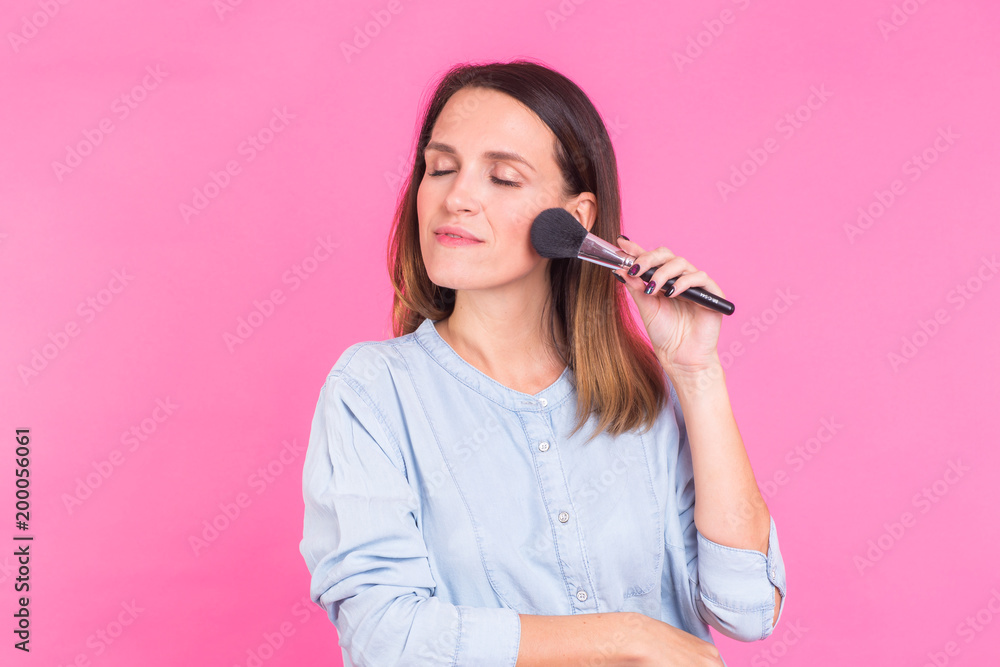 Beautiful young woman applying cosmetic powder on her face with tassel, skin care concept Beautiful young woman applying cosmetic powder on her face with tassel, skin care concept