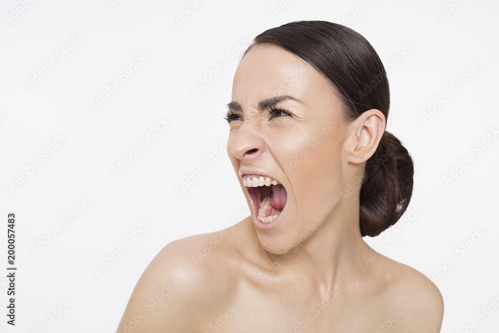 Portrait of a young woman screaming sideways with anger. Portrait of a young woman screaming sideways with anger.