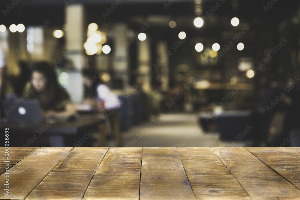 Wood Table top Counter with blurred of coffee shop or modern library . Abstract, freelancer working on laptop in cafe with a cup of coffee.