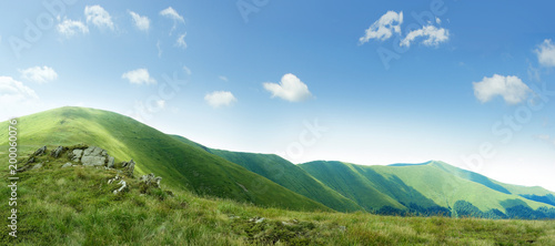 on top of green Carpathian mountains range with blue sky on a sunny day, empty landscape background of wide panorama