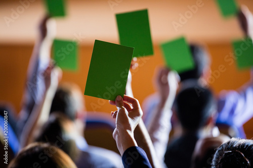 Rear view of business executives show their approval by raising hands photo