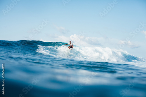 handsome athletic man surfing on ocean wave