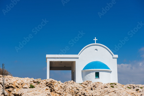 Small Greek white chapel with a blue roof