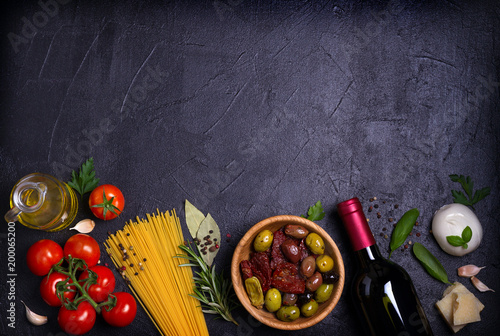 Selection of healthy food. Italian food background with spaghetti, cheese, olives, tomatoes, basil and wine. Slate banner background. View from above, top, flat lay with room for text