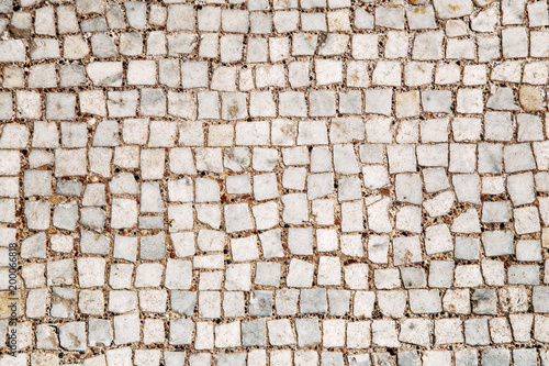 Stone pavement texture, abstract background of old cobblestone pavement close-up. Front view.