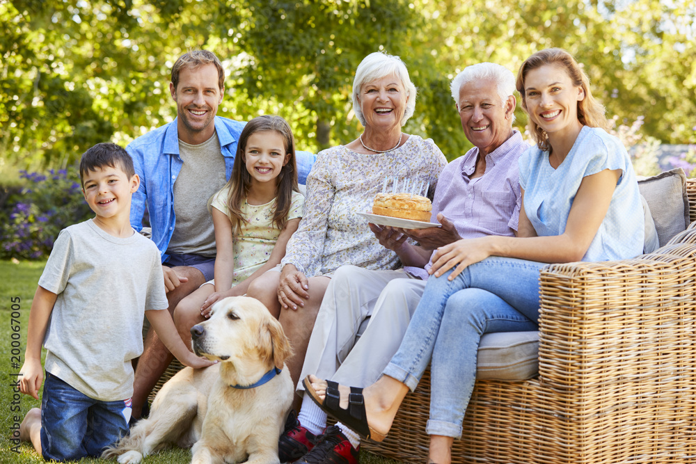 Three generation family petting a dog in the garden Three generation family petting a dog in the garden