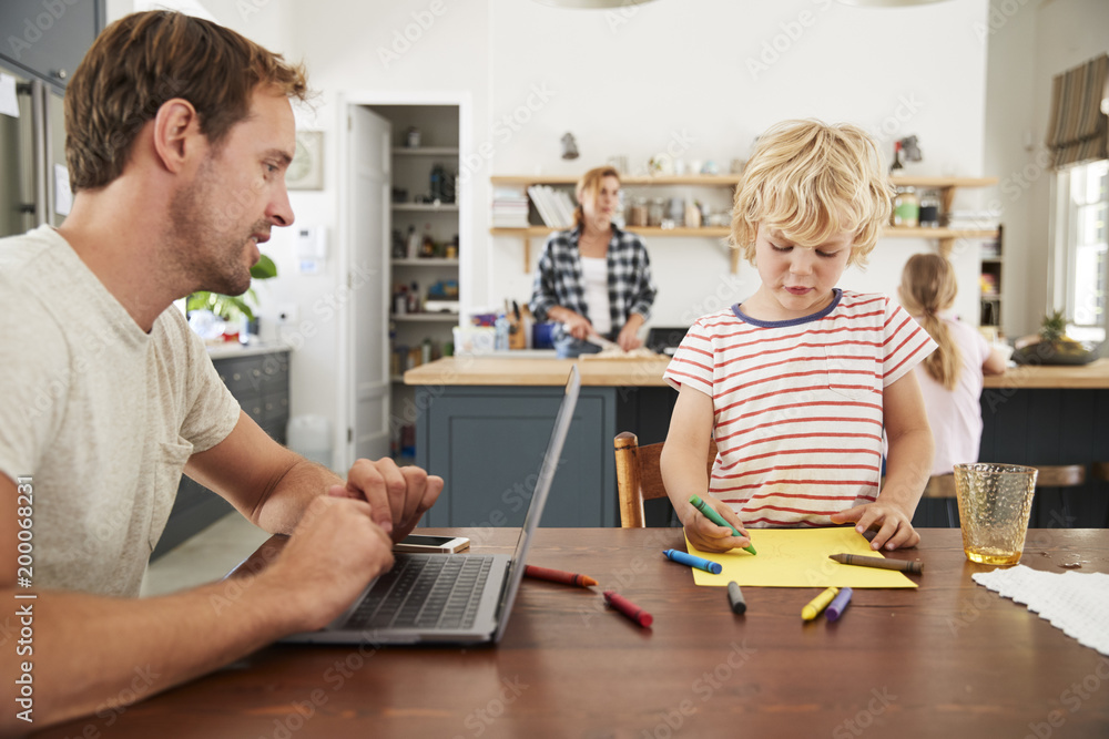 Obraz premium Busy family kitchen, dad and son working at table, close up