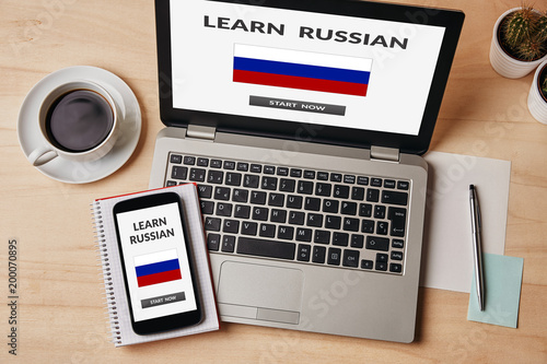 Learn Russian concept on laptop and smartphone screen over wooden table. All screen content is designed by me. Flat lay
