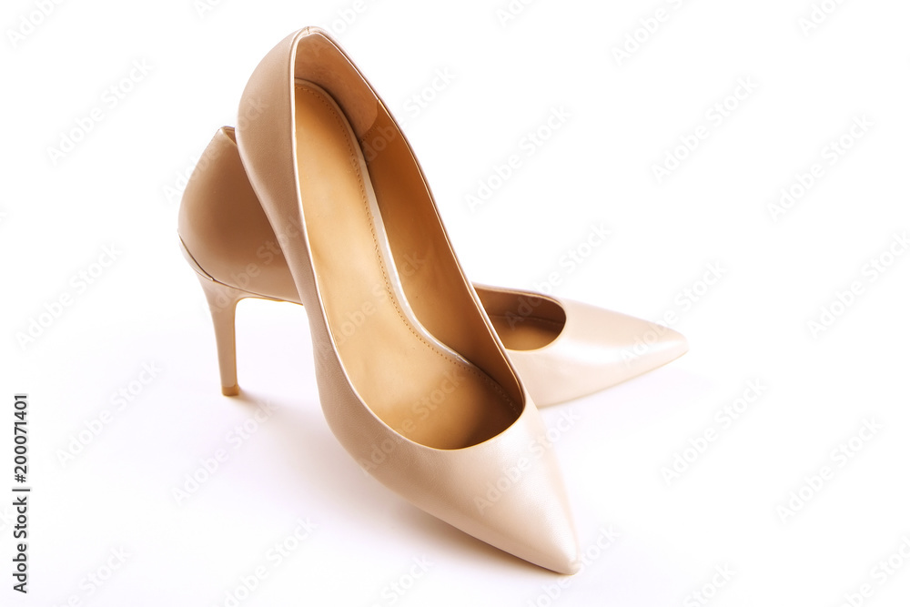 Stylish classic women's beige leather shoes with medium high heels shot from top and from the side, isolated on solid white background. Copy space, top view, flat lay. Shoe sale / clearance ad concept