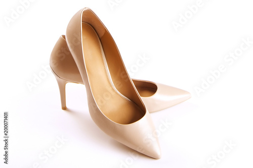 Stylish classic women's beige leather shoes with medium high heels shot from top and from the side, isolated on solid white background. Copy space, top view, flat lay. Shoe sale / clearance ad concept