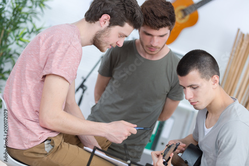 young men composing music one playing guitar