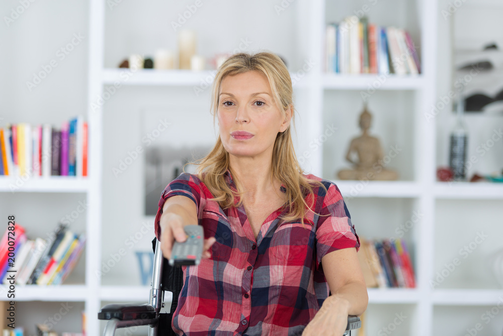 disabled woman watching tv in the living room at home disabled woman watching tv in the living room at home