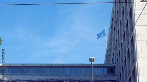 tracking shot on the facade, with the flag of the Fao waving in the blue sky