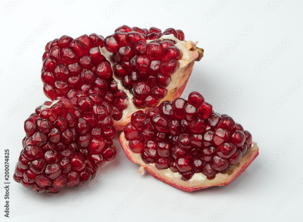 Part of delicious juicy ripe pomegranate and pomegranate seeds scattered around. Part of delicious juicy ripe pomegranate and pomegranate seeds scattered around.