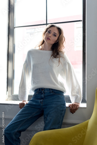 portrait of beautiful young brunette woman sitting in windowsill and looking at camera Free Download portrait of beautiful young brunette woman sitting in windowsill and looking at camera - GFXLoad