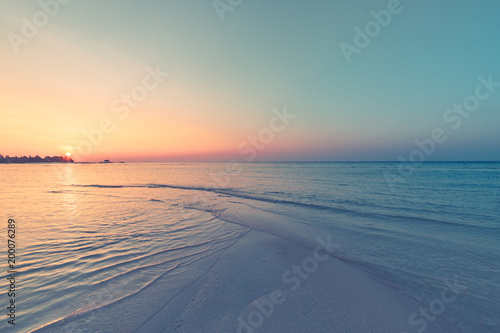 Peaceful and tranquil beach scene, soft waves and sunset sky