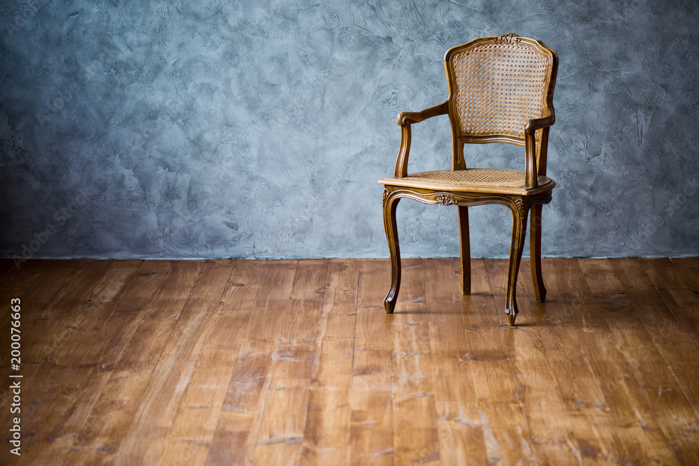 old chair on a gray wall background. old chair on a gray wall background.