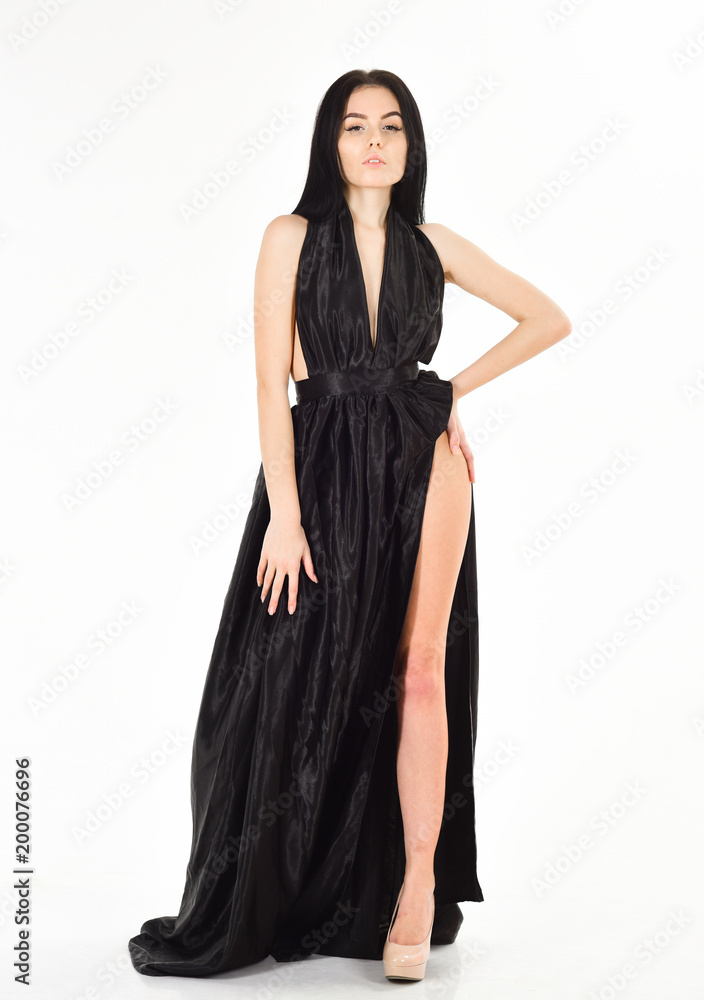 Lady, sexy girl in dress. Attractive girl wears expensive fashionable evening dress with erotic slit. Fashion dress concept. Woman in elegant black long evening dress with decollete, white background.